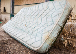 Discarded mattress against a wall